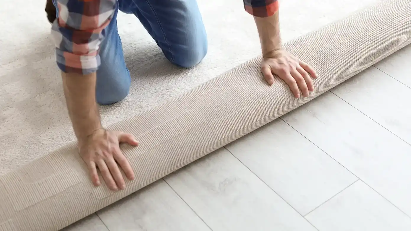 man rolling out new carpet flooring